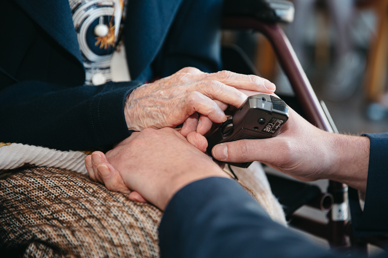 A visitor holding a listening device while speaking to María Branyas Morera at her 116th birthday party.