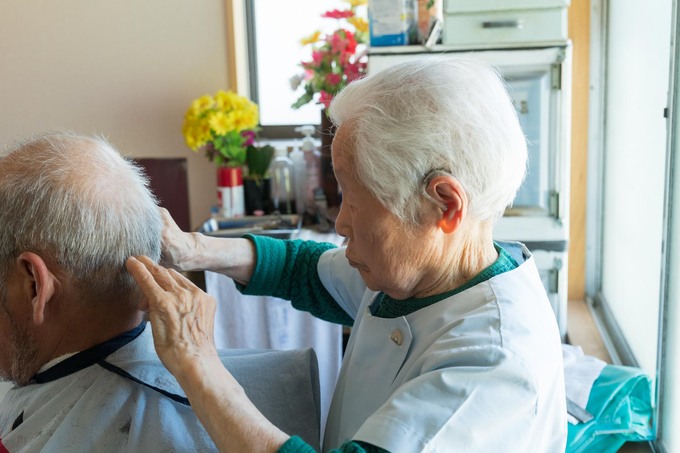 In August 2022, aged 105, giving the customer a haircut. (Source: esse-online.jp)