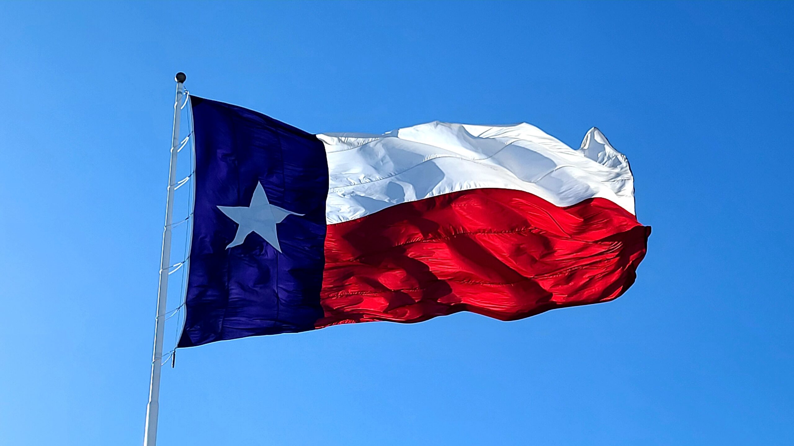 The Texas flag on a clear, windy day