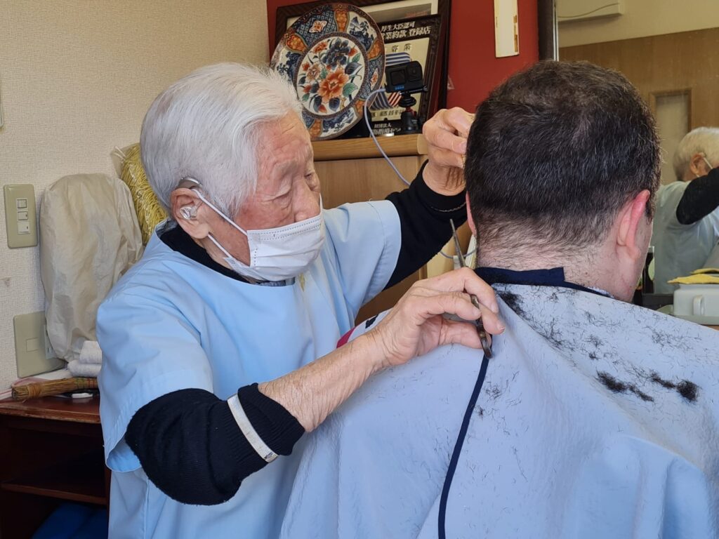Hakoishi-san giving a haircut to Ben Meyers, the CEO of LongeviQuest.