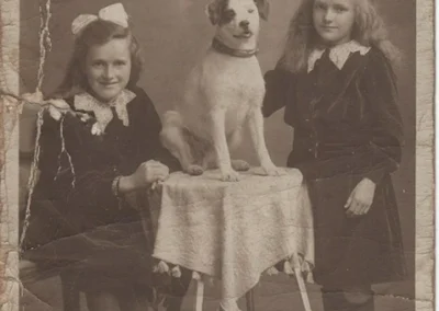 Annie, aged 8-10, seated left with her pet dog and younger sister Sue. (Source: The 110 Club)