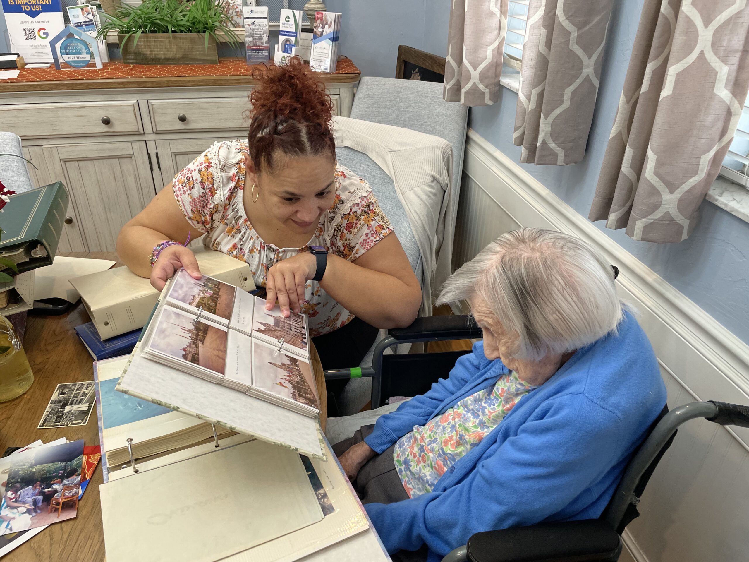 Amanda Flores helping Veronica Pheney peruse one of her photo albums.