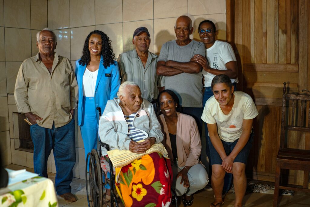 Izabel shown with LQ researcher Iara Souza, sons Vicente, João, and Sebastião, granddaughters Dr. Ana Tássia and Tádea Brígida, and caregiver Vanderléia.