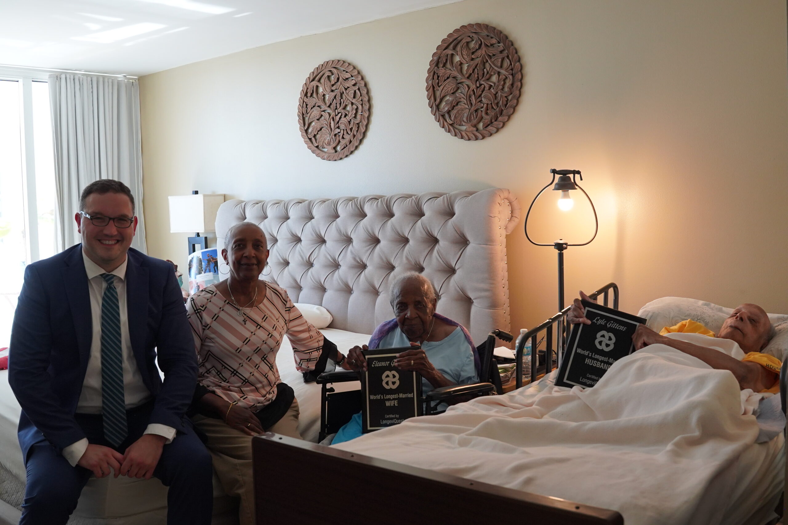 Eleanor and Lyle Gittens with awards honoring their record-setting marriage, with their daughter Angela Gittens and LongeviQuest's Ben Meyers.