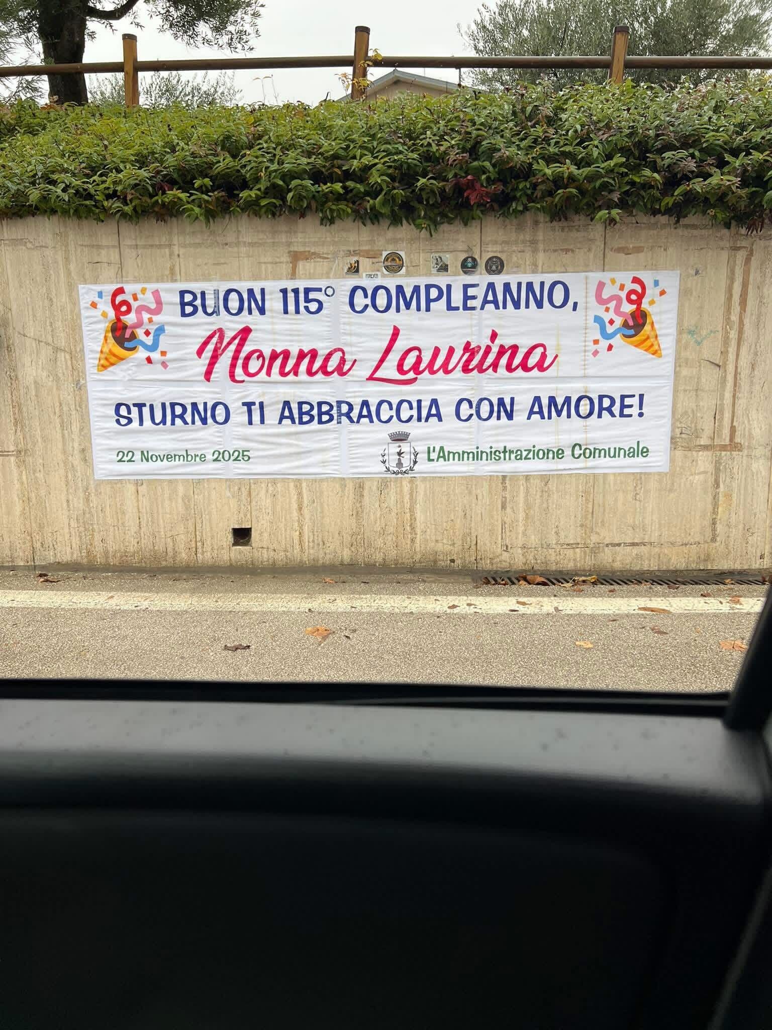 A sign commemorating the 115th birthday of Lucia Laura Sangenito, oldest living person in Italy, by her local government.