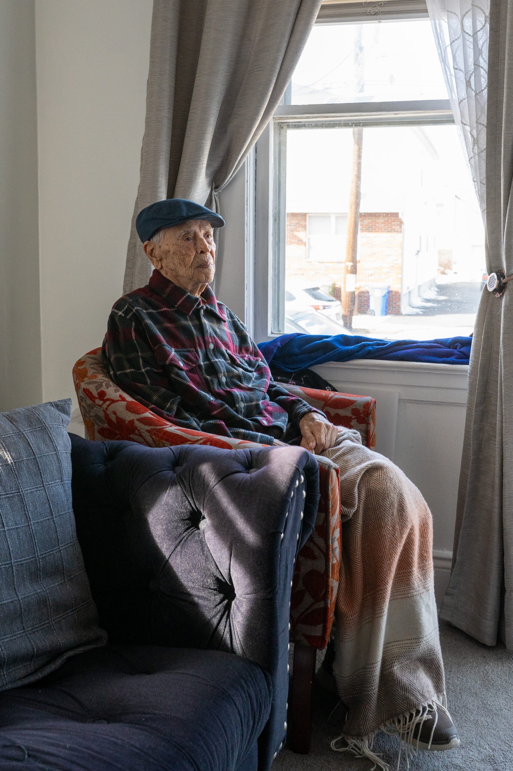 Luis Cano in his favorite chair by the window overlooking a busy street in Linden, New Jersey.